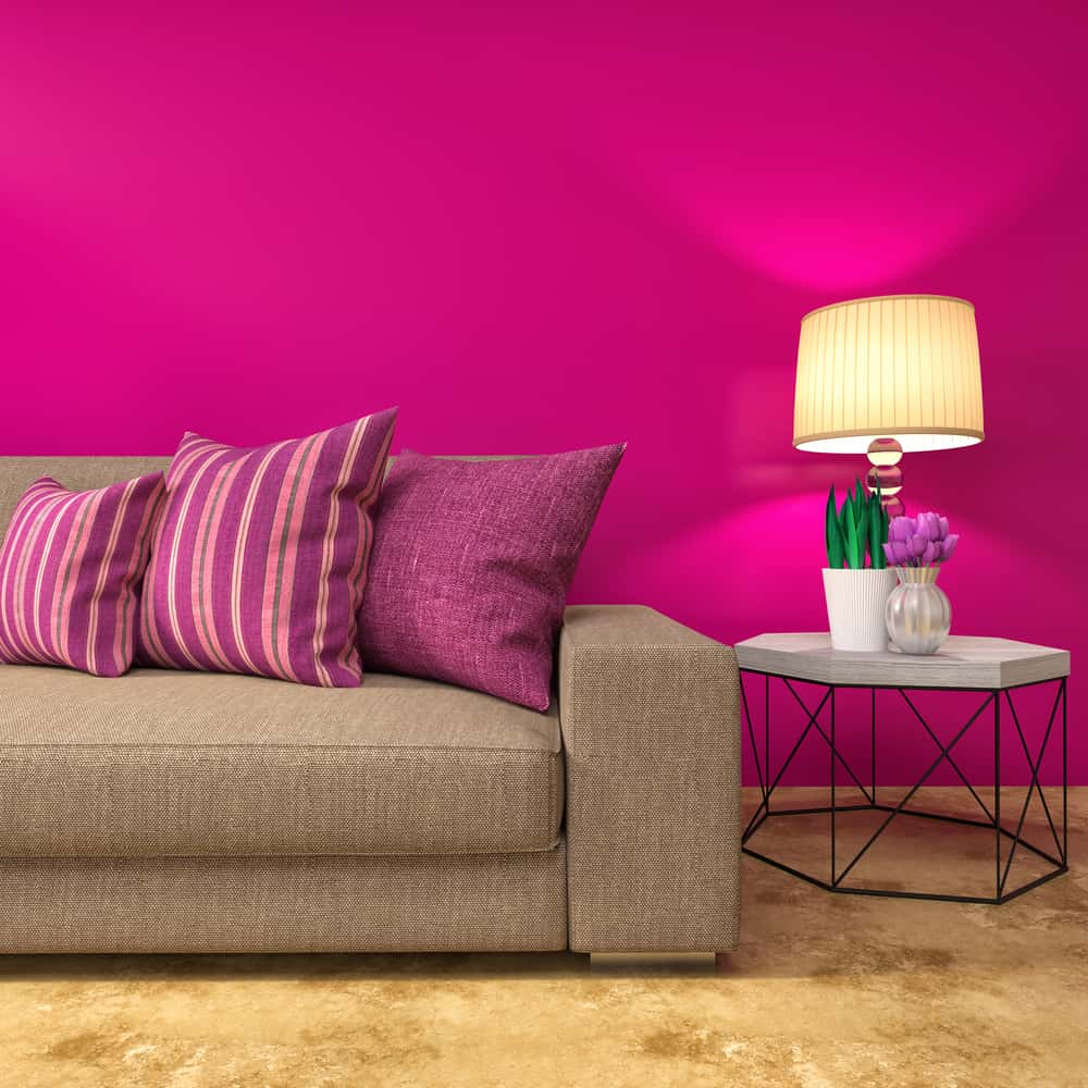 dark pink wall and brown sofa