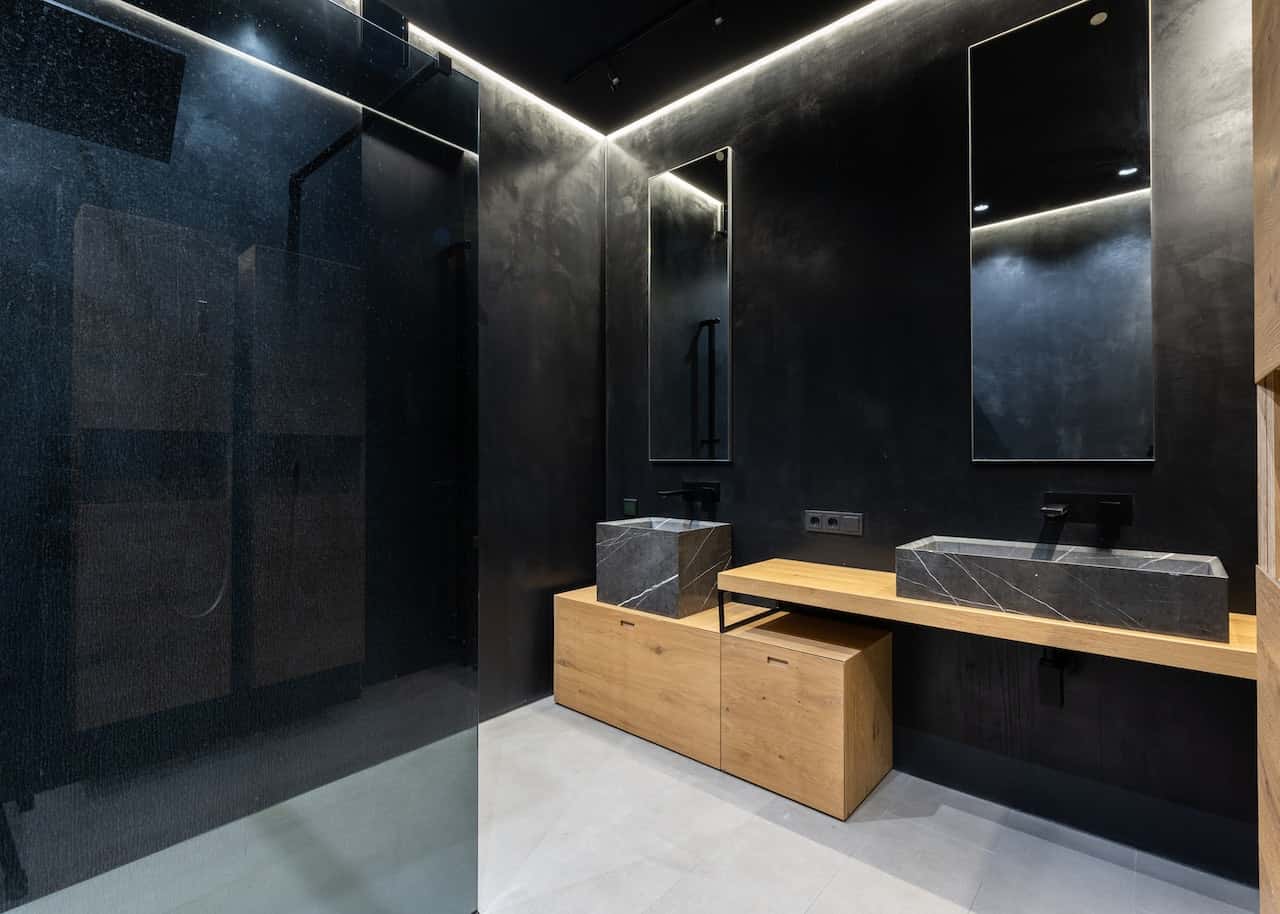 black bathroom with backlit mirror