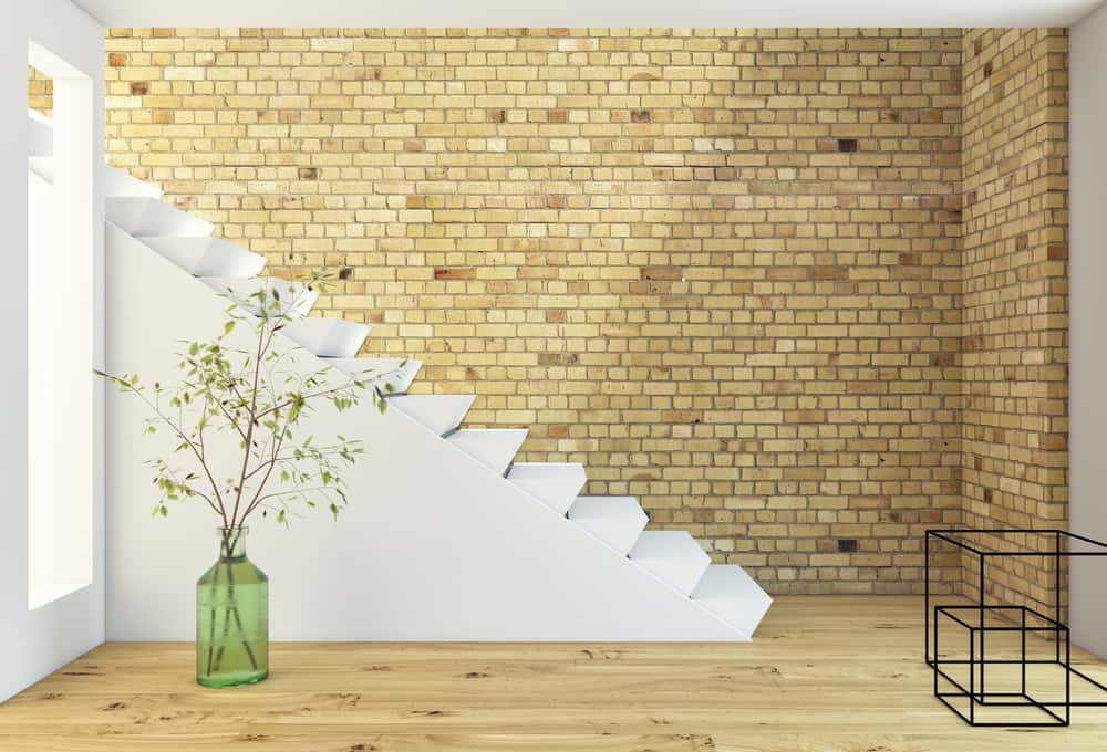 white staircase design with brick wall